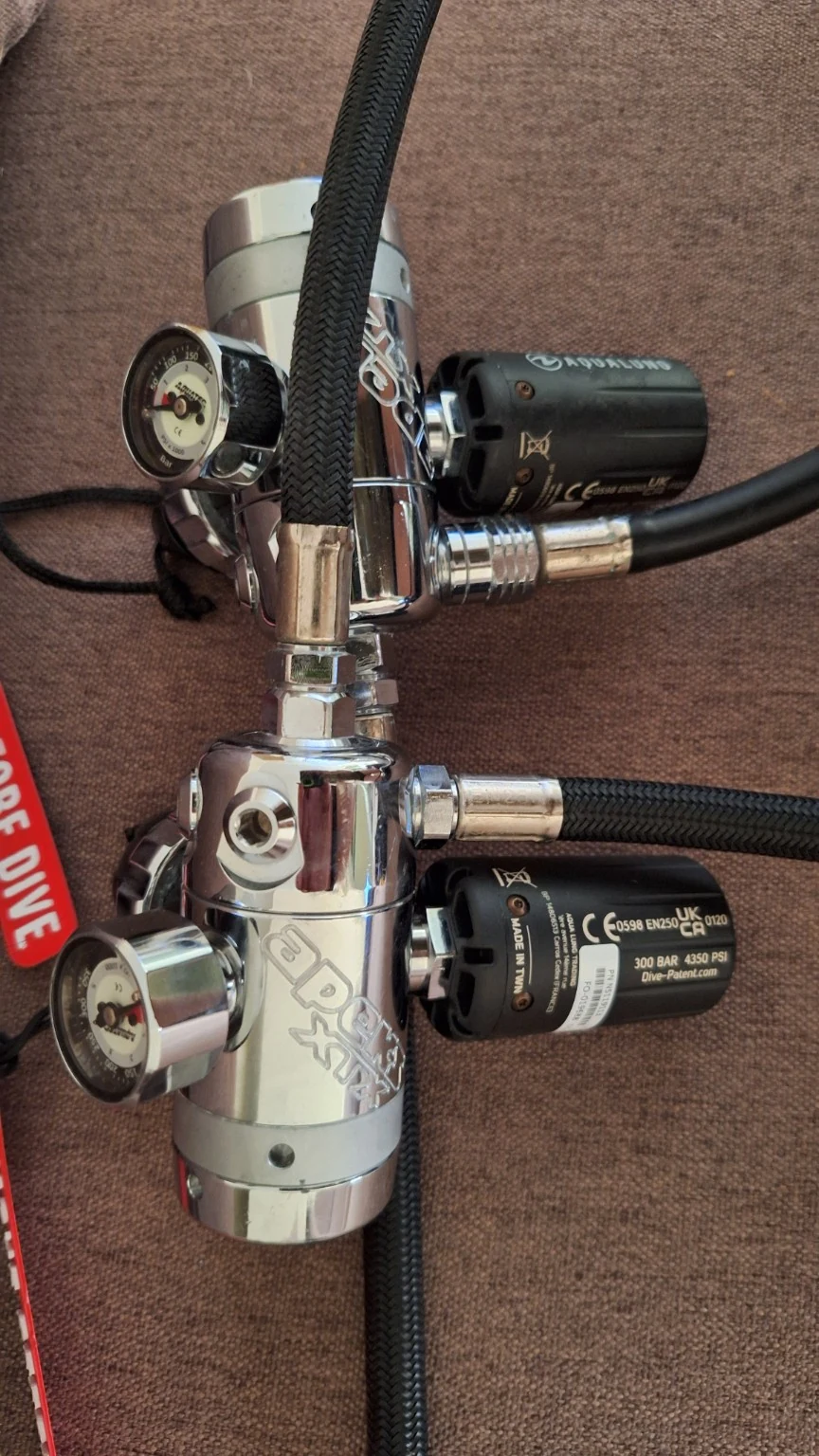 Two Apeks DST sidemount first stages with wireless transmitters, compact button gauges and routed hoses